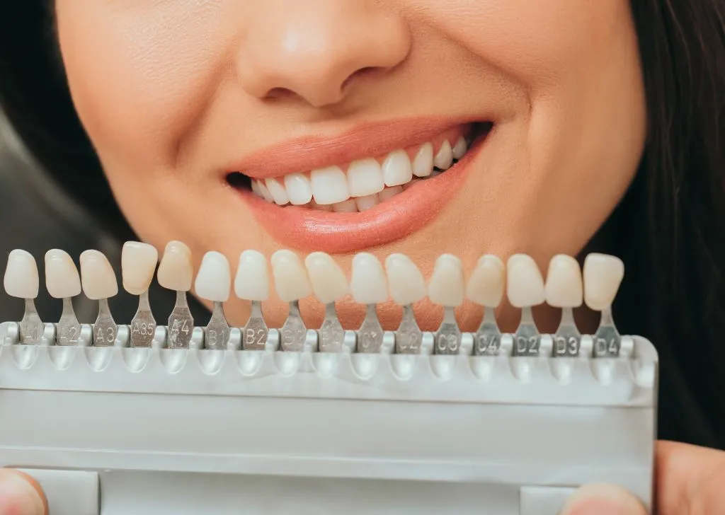 Patient checking out the shades of veneers that match her teeth.