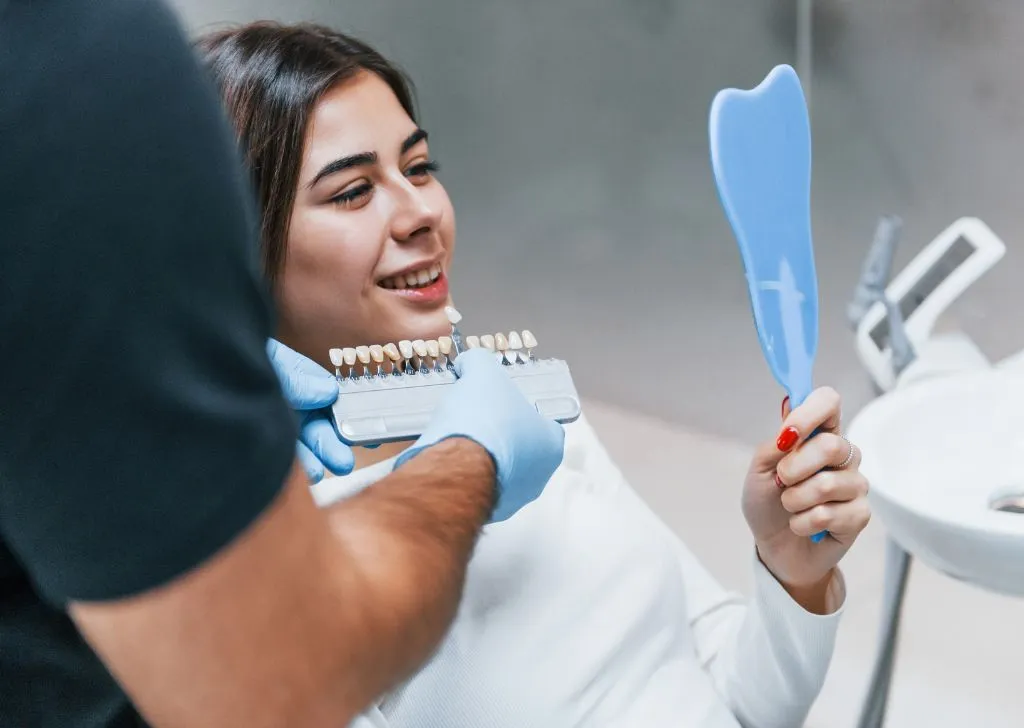 Woman checking out the shades of her dental veneers.