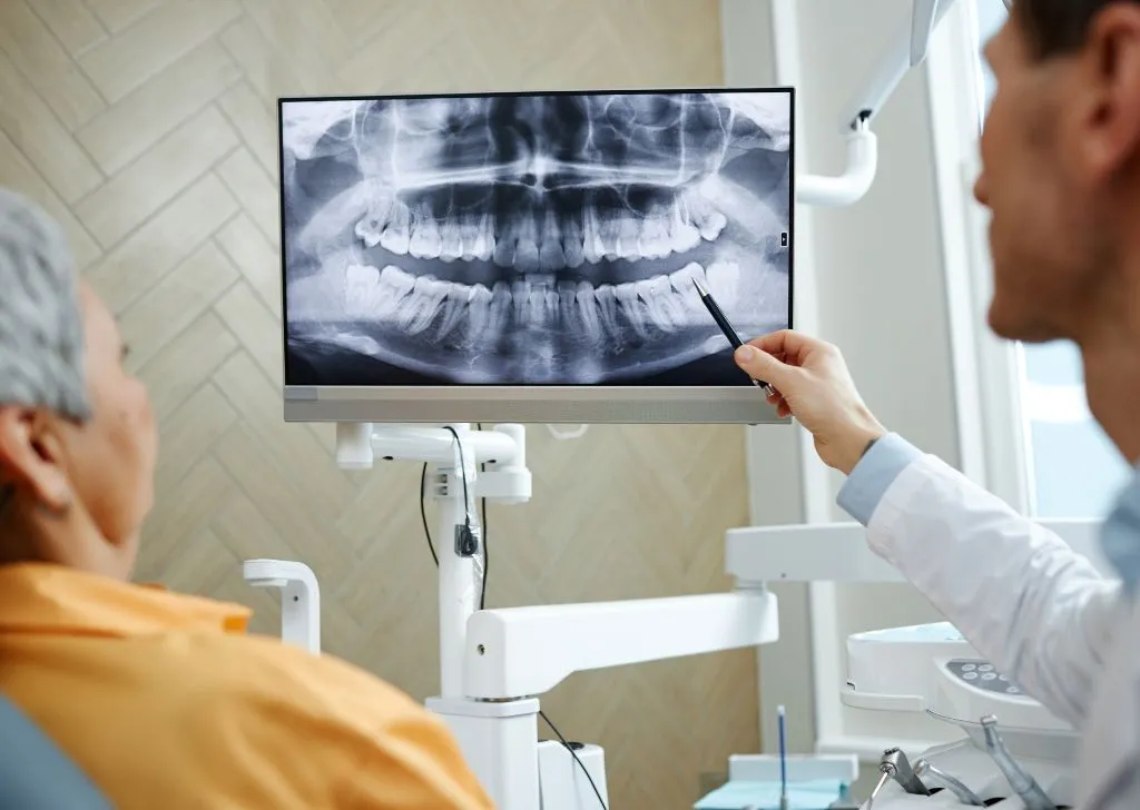 A dentist explaining a patient's dental x-ray.